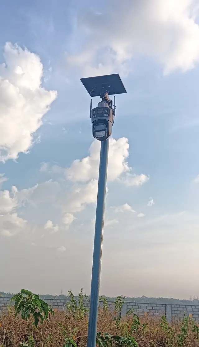 Solar panel powered 4G CCTV camera mounted on a tall pole above open land
