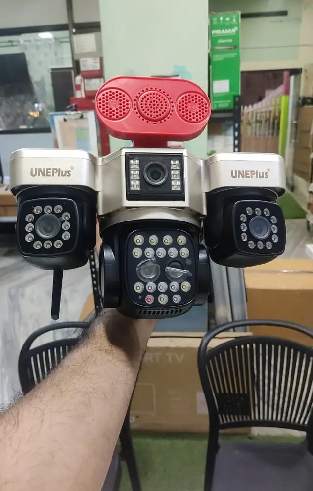 Hand holding a multi-lens PTZ security camera in the showroom
