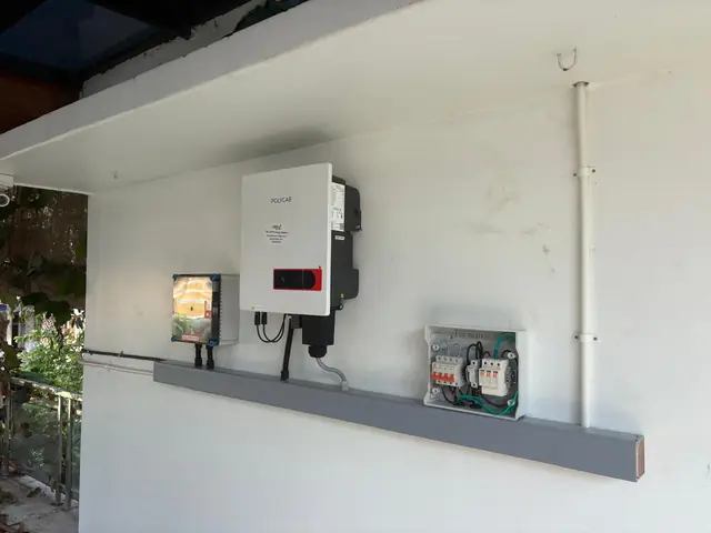 Solar inverter, isolator and breaker box mounted on an outdoor wall with conduit